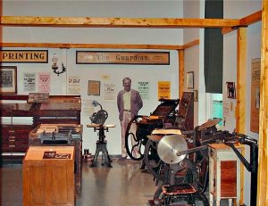 David B. Russell's printing shop and the old Bay Roberts Guardian newspaper . The printing press from the early 20th century is part of the display. Local visual artist Hilary Cass designed exhibits, including a life size depiction of David Russell.